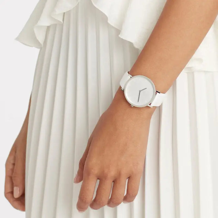 Ladies' stylish white watch with minimalist design, complementing the elegant white dress in the image.