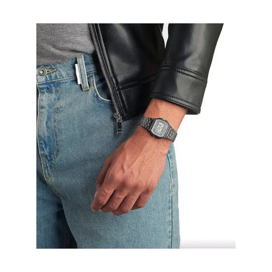 Vintage men's watch in silver tone case on model's wrist, complementing the stylish look with a leather jacket and denim jeans.