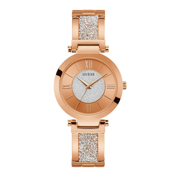 Elegant rose gold-toned ladies watch with sparkling crystal accents, featuring the Guess logo and Roman numeral hour markers. The timepiece is placed on a white background, highlighting its lustrous and fashionable design.